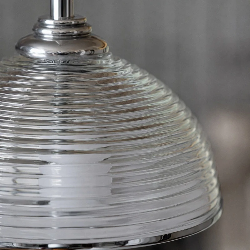 Close detail of the clear glass shade profile and metal hardware