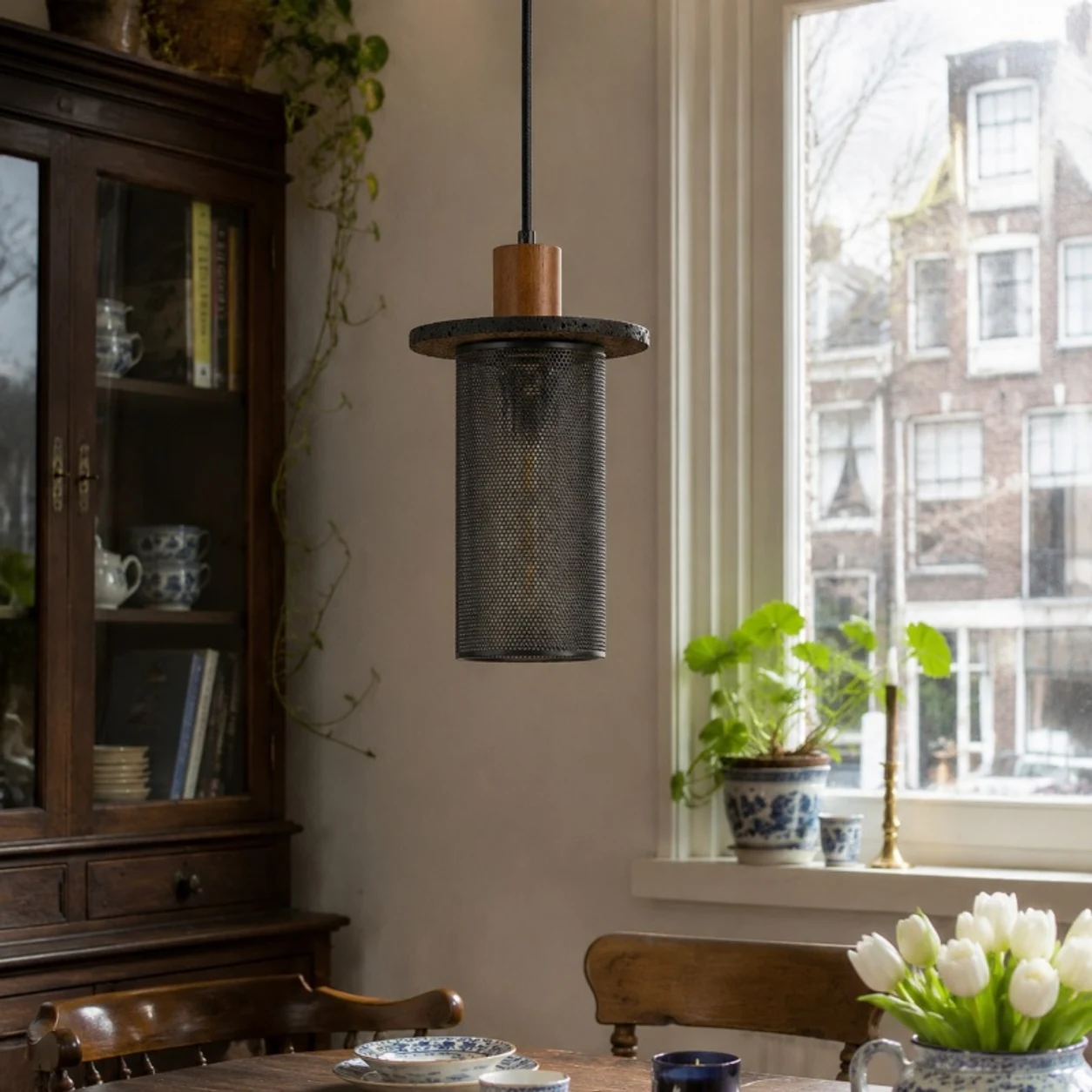 Black woven mesh pendant light beside a vintage cabinet