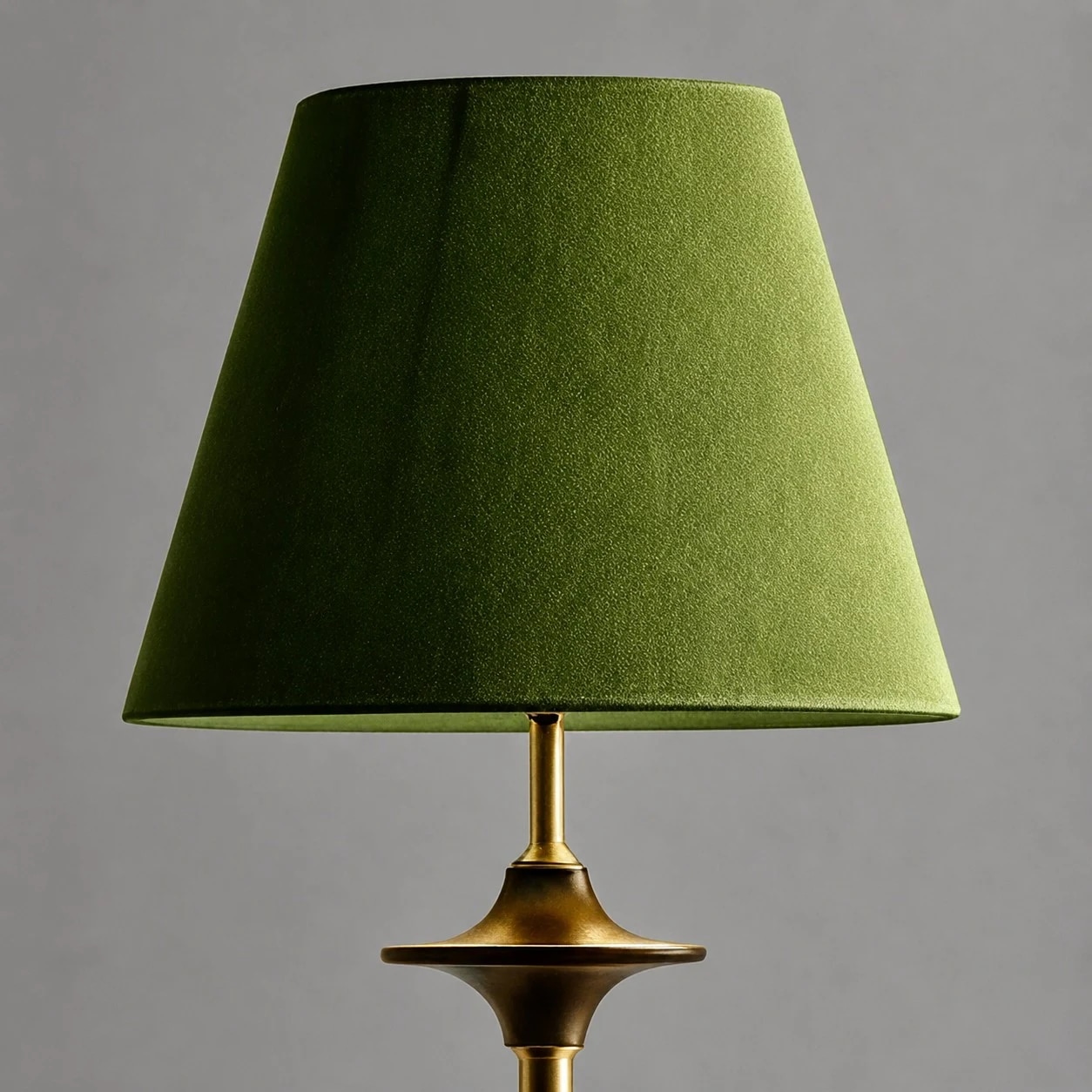 Close view of green fabric shade and brass tone stem