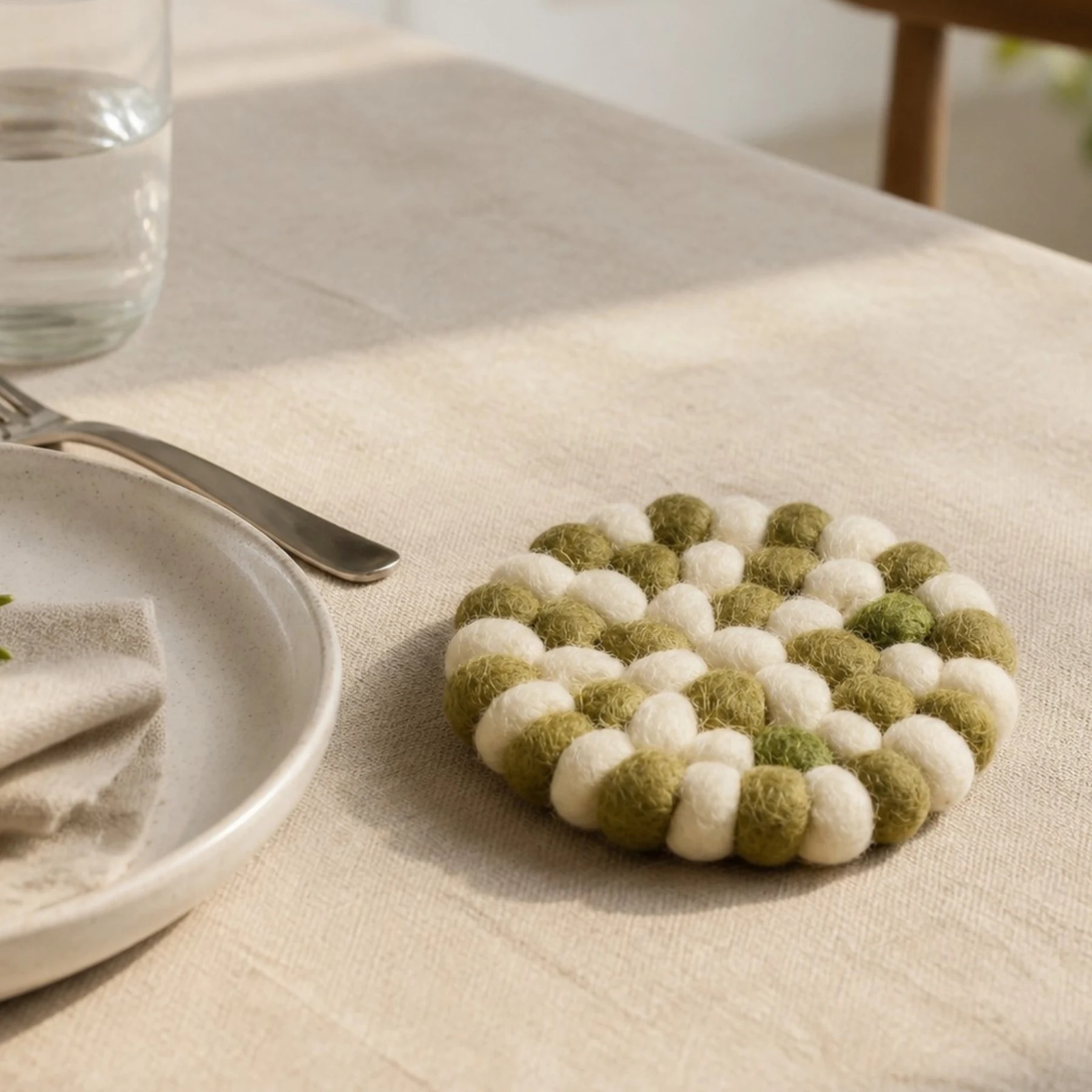 Round felt coaster beside glassware