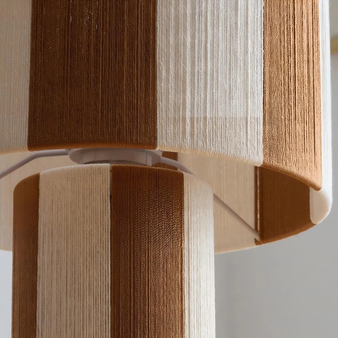 Close detail of the woven striped lamp shade texture and layered panels